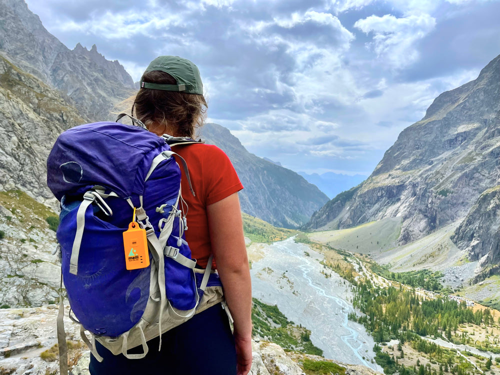Walkers in the Alps with a MeiliGPS tracker clipped to a rucksack